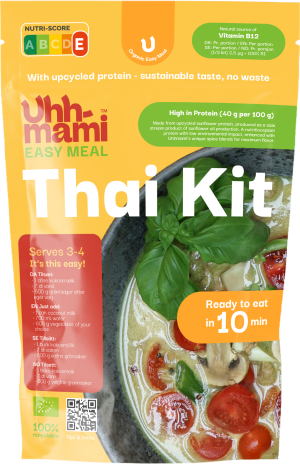 Ljusgul förpackning för ett ekologiskt thailändskt soppkit märkt Uhhmami. En skål med soppa med körsbärstomater och basilika. Texten betonar hållbarhet.